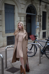 a lady wears a beige sweater with matching skirt  and a trench coat